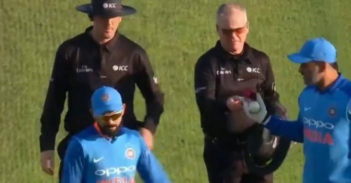 Dhoni taking the ball from the umpire