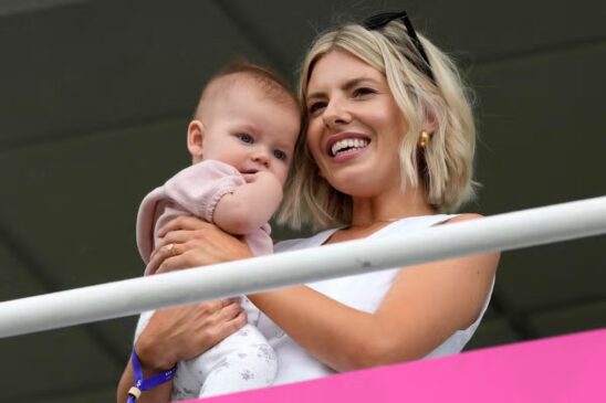 Mollie King holding Annabelle at the stands in The Oval