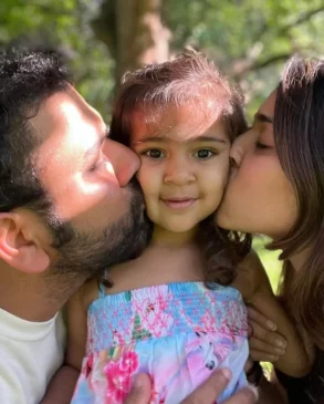 Ritika and Rohit kissing their daughter 